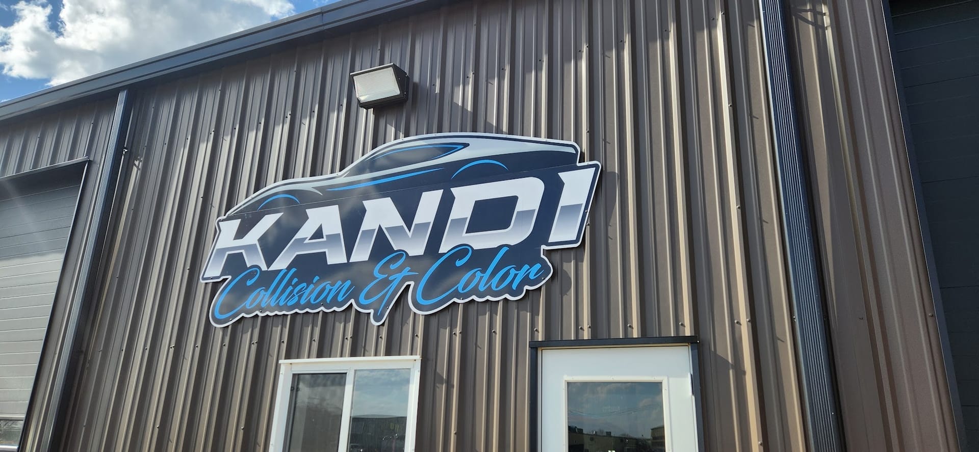 Kandi Collision & Color sign mounted on the shop's steel exterior wall