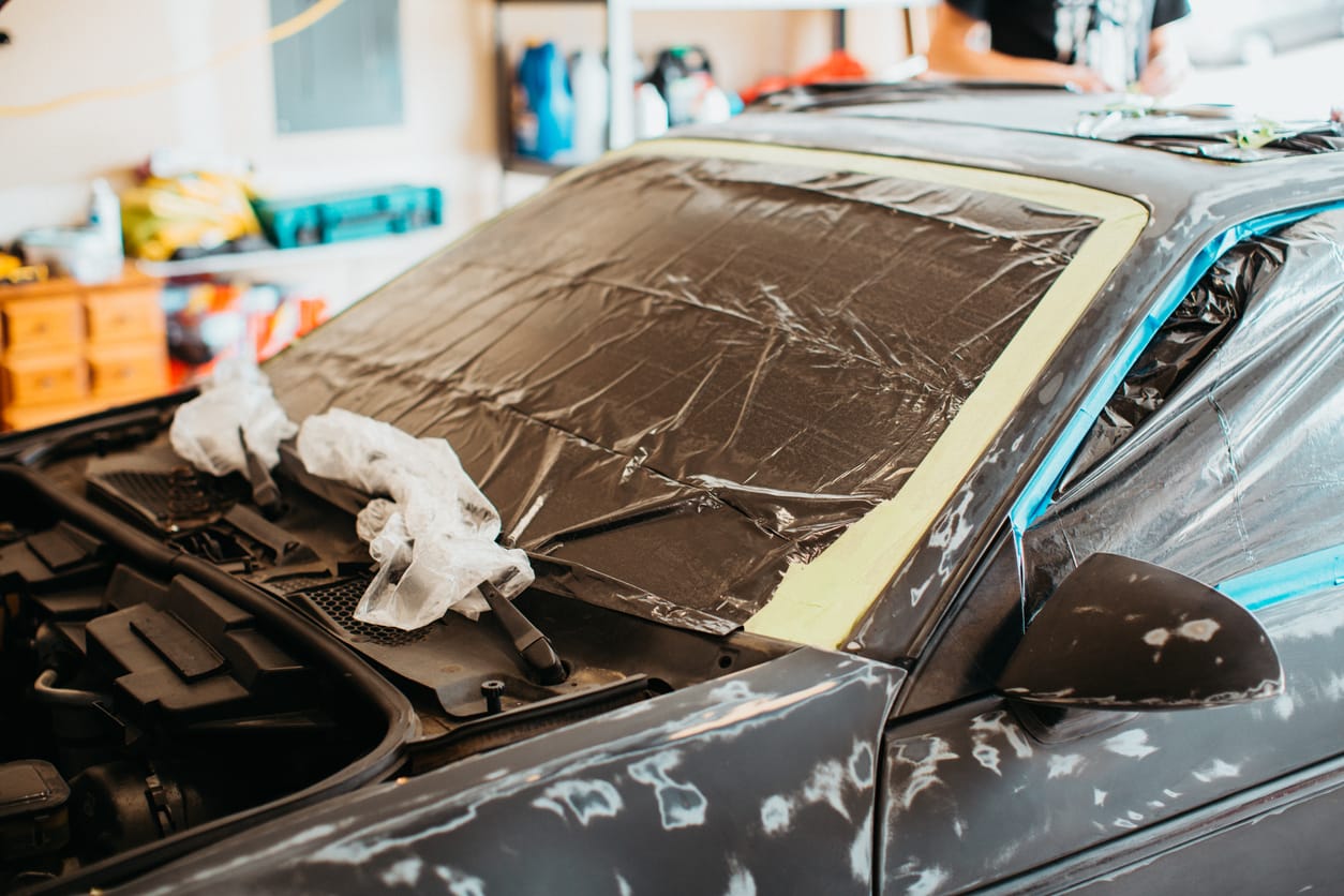 Car masked off with film and tape, sanded down and ready for the booth