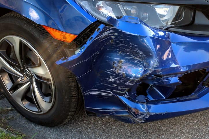 Blue car with heavy front-end collision damage