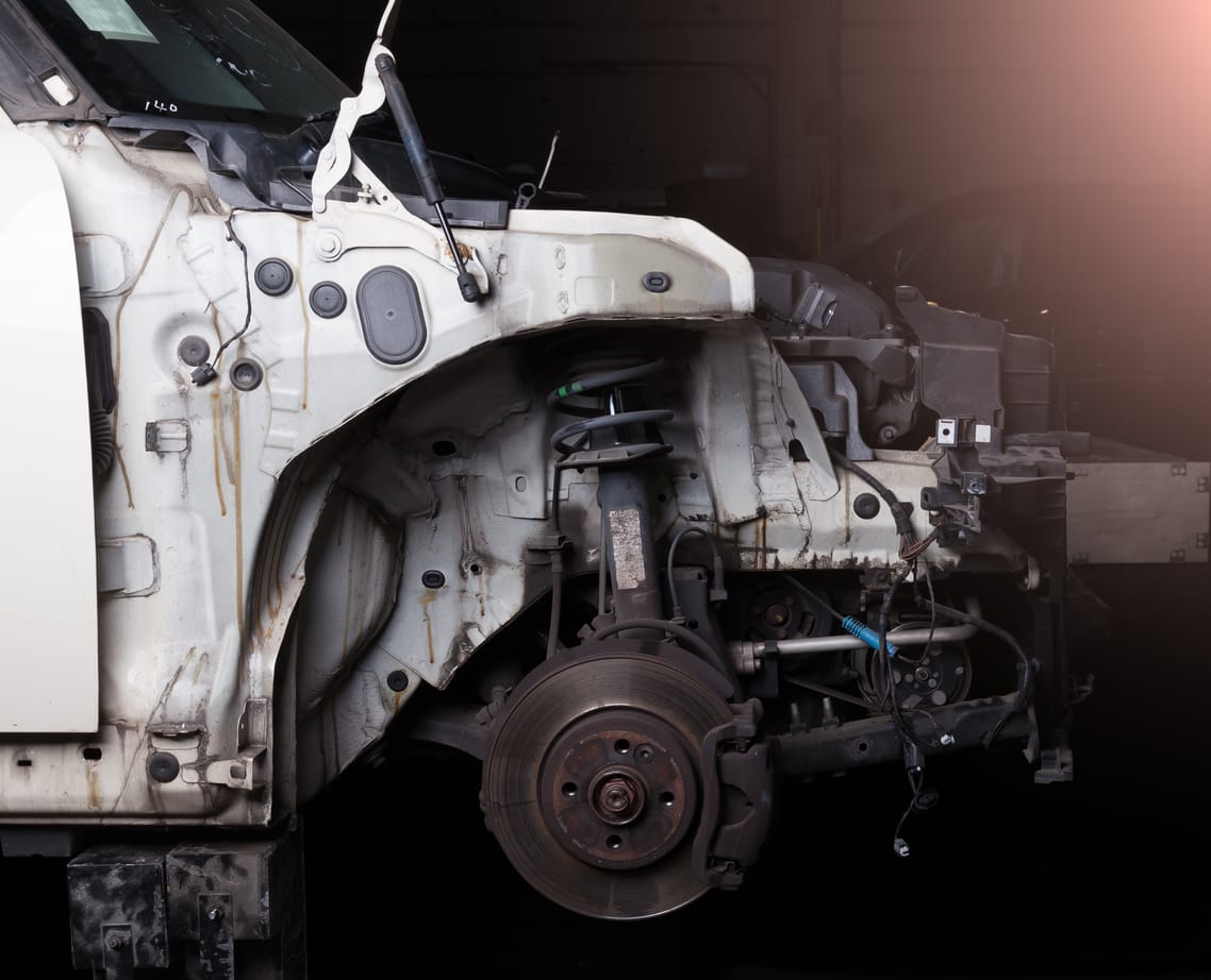 Car stripped to its front frame rails and suspension during collision repair