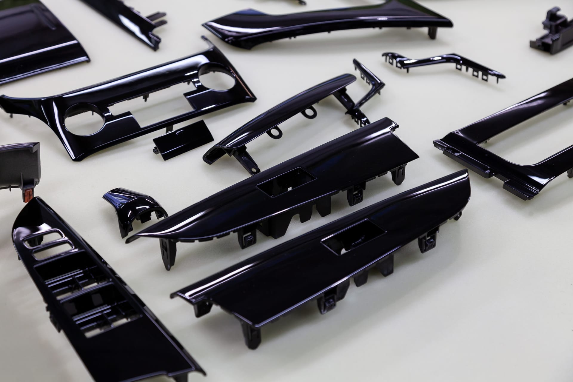 Row of gloss black interior trim pieces laid out after refinishing